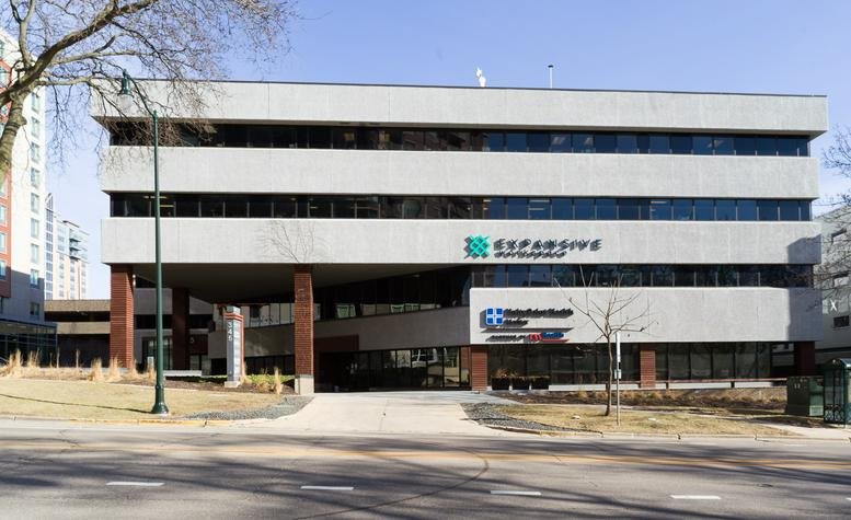 Exterior view of the multi-story 345 W Washington Avenue building with its distinct concrete and glass facade.