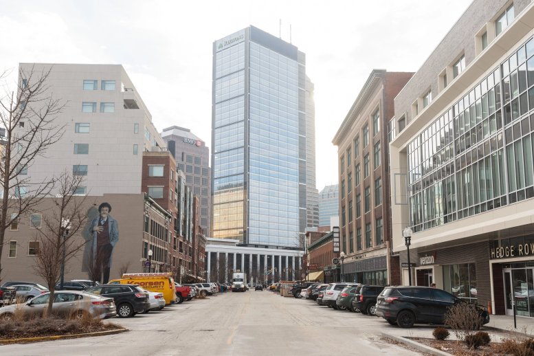 Street-level exterior view of 350 Massachusetts Avenue, Indianapolis showing modern buildings and a city skyline.