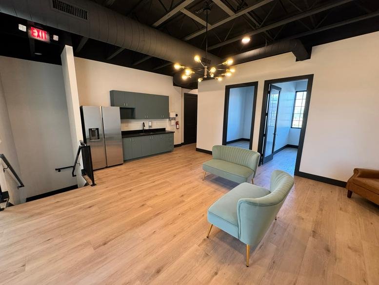 Spacious communal lounge at 352 South 2000 West, Pleasant Grove, Utah featuring teal chairs and a modern kitchenette.