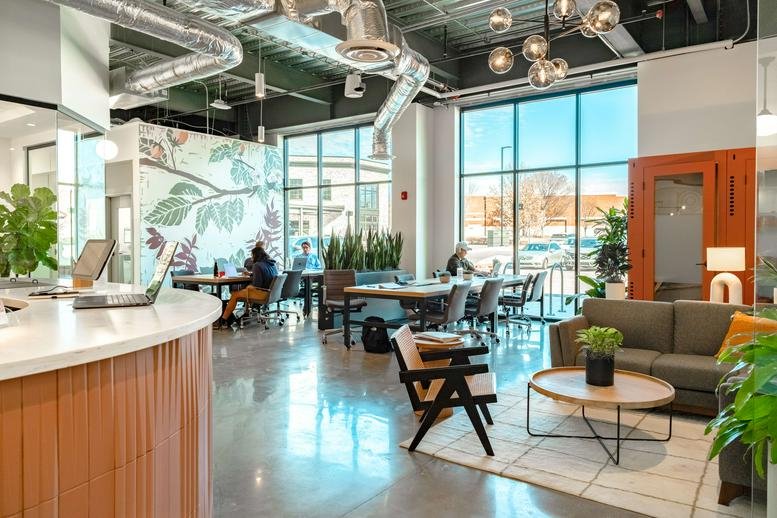 Spacious interior of the Olsson Building featuring high ceilings, exposed ductwork, and abundant natural light.