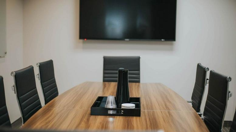 Close-up of a boardroom table set with a water pitcher and glasses.