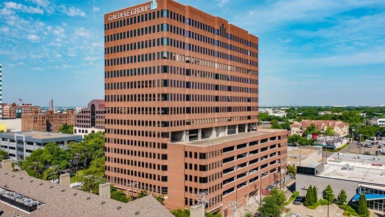 Exterior view of the red brick 3710 Rawlins St building under a clear blue sky.