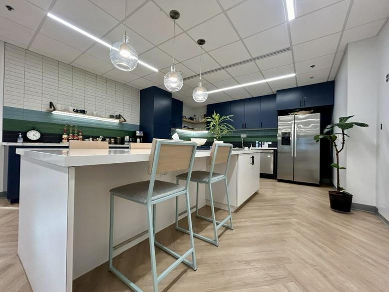 Modern kitchen and bar area at 3838 North Central Avenue, Suite 900, featuring sleek navy cabinetry.