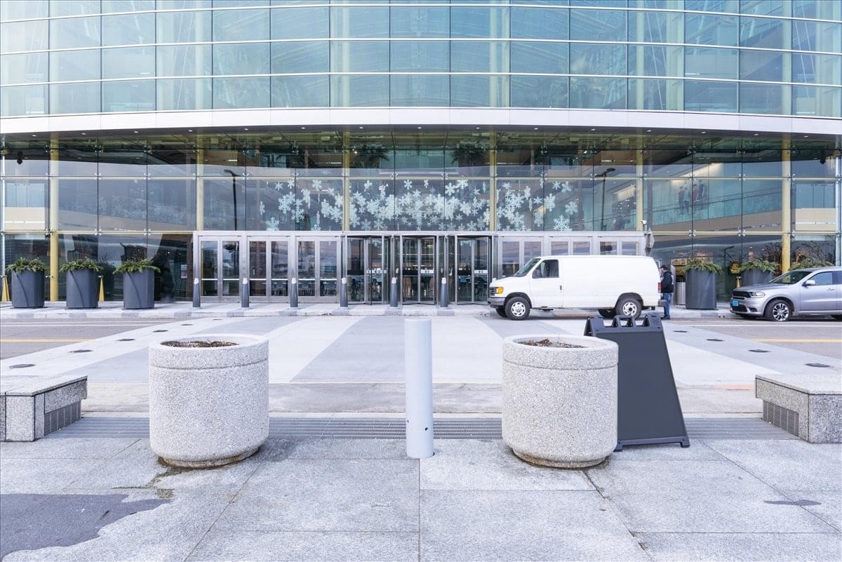 Entrance and glass facade of the 400 Renaissance Center with a white van parked in front.