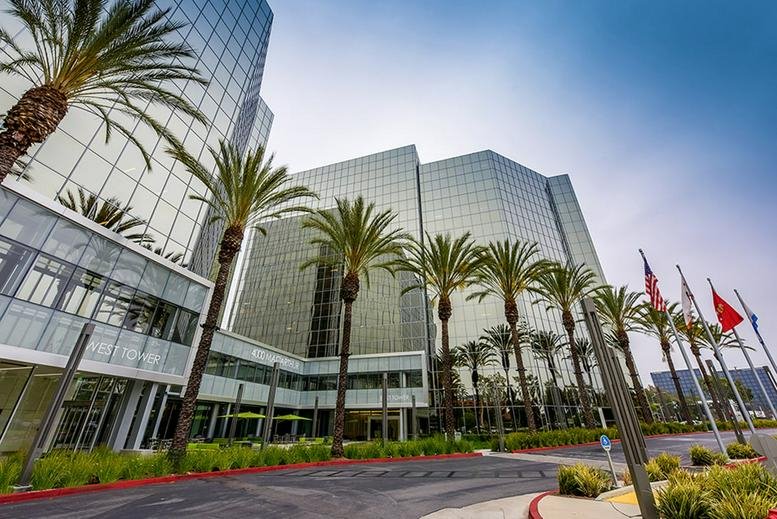 Exterior view of the glass towers at 4000 MacArthur Blvd surrounded by palm trees.