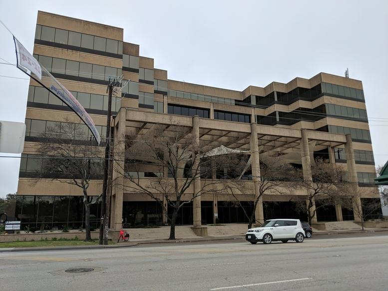Exterior view of the multi-story office building with a concrete and glass facade.