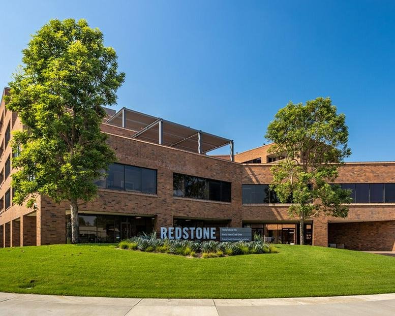 Exterior view of the brick facade and manicured lawn at Redstone, 4041 Macarthur Boulevard.