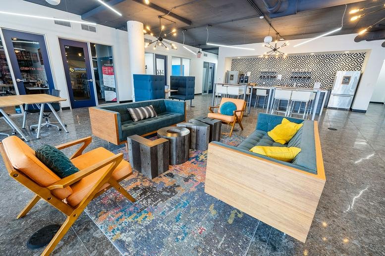 Spacious communal lounge at 405 W Superior St featuring colorful sofas and an industrial kitchen.