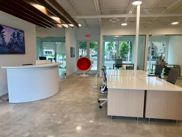 Reception area at 406 Lucerne Avenue with a curved white desk and red spherical chair.
