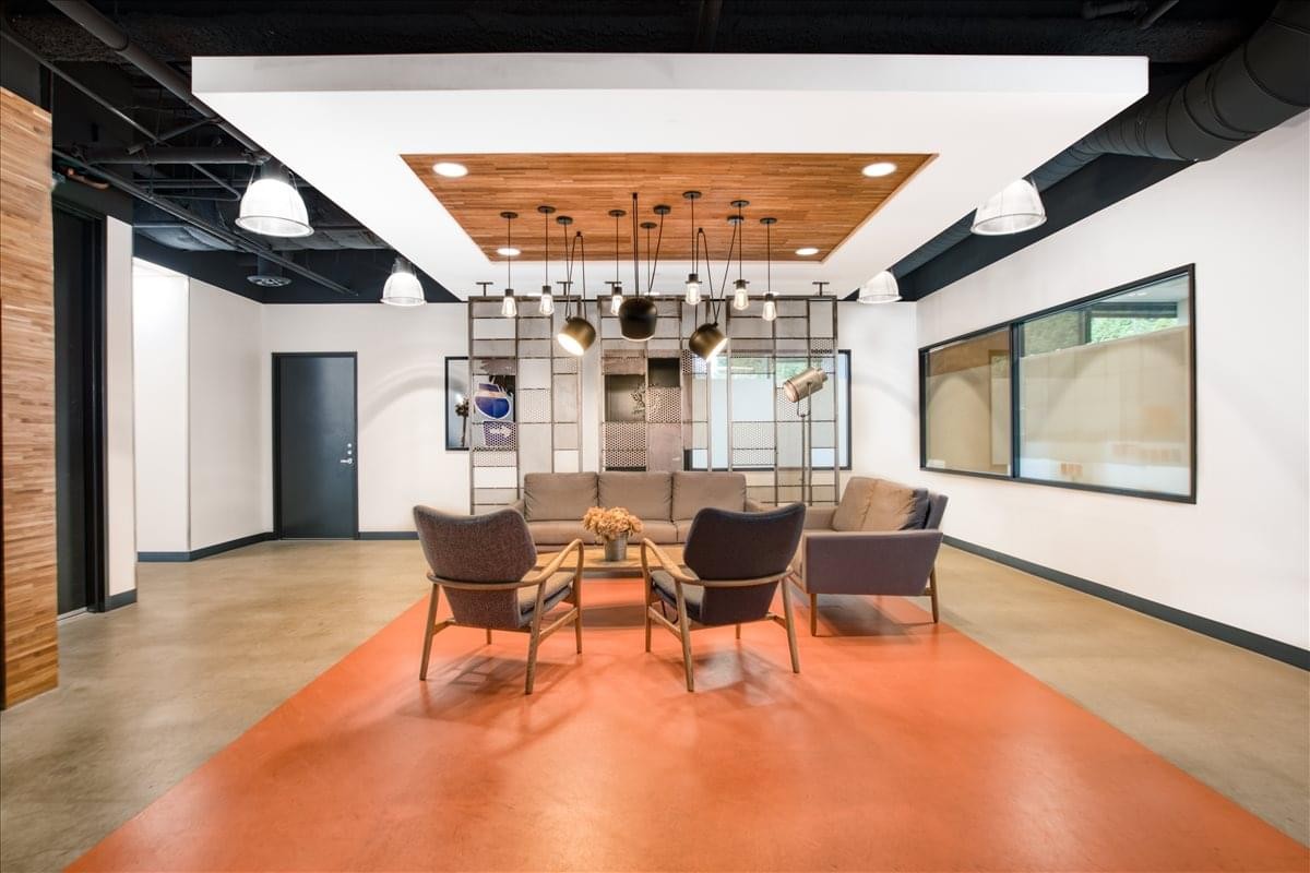 Spacious common area at 4100 W. Alameda Avenue 3rd Floor featuring warm lighting and orange flooring.