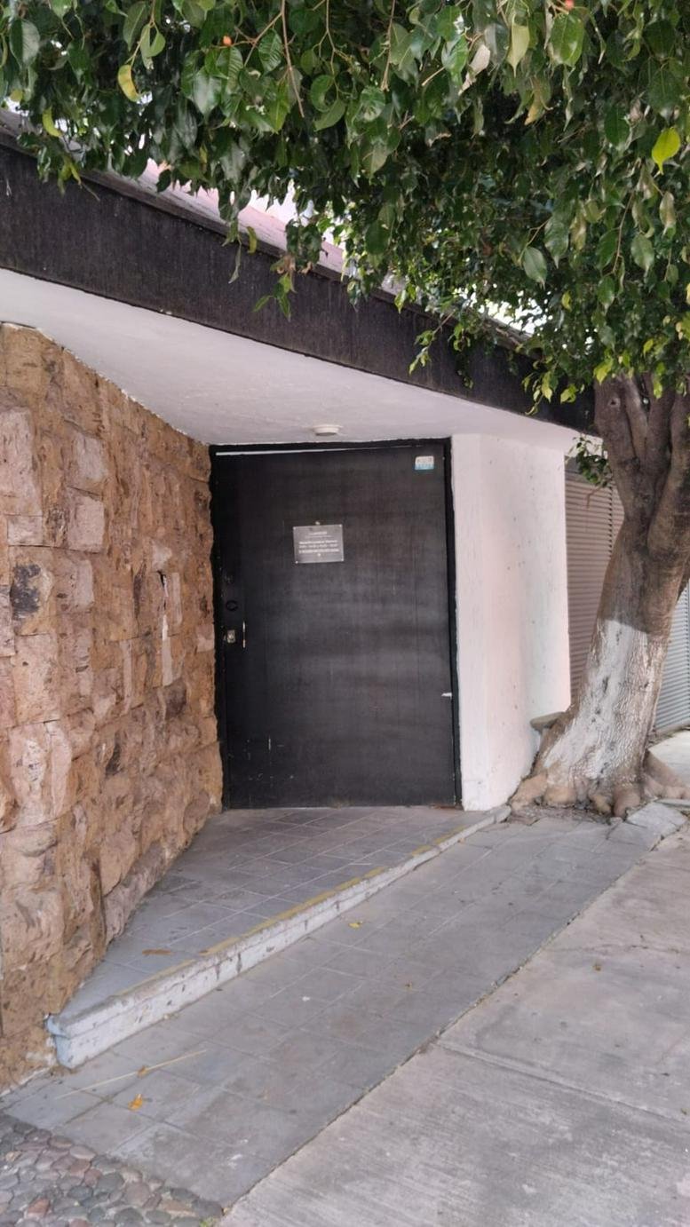 Exterior entrance at Avenida Guadalupe, Providencia, Zapopan featuring a stone wall and black door.