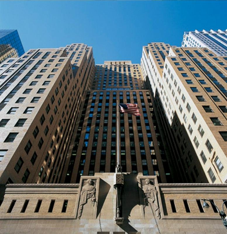 Dramatic upward perspective of the building's Art Deco architecture against a blue sky.