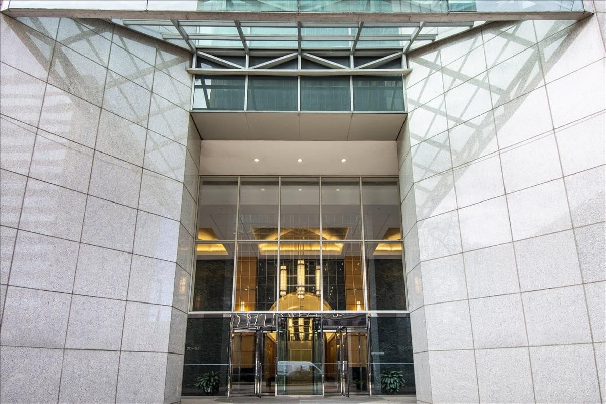 Modern glass and stone entrance of the Downtown Wells Fargo Center.