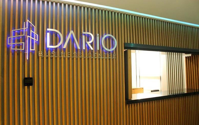 Sleek wooden wall at Dario Business Center, Providencia, Guadalajara with illuminated brand signage.