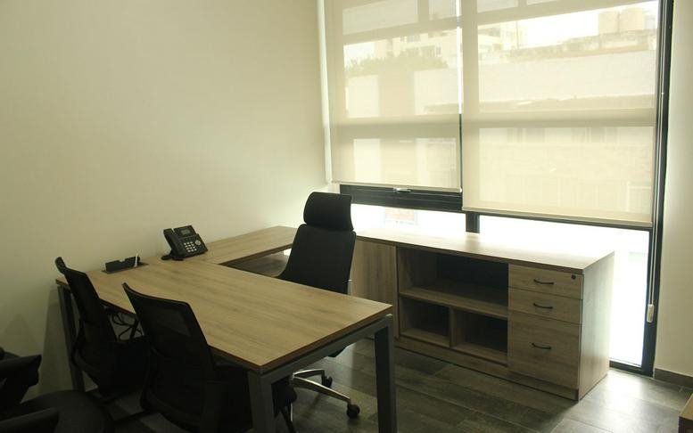 Executive office suite with an L-shaped desk, built-in cabinetry, and window blinds.