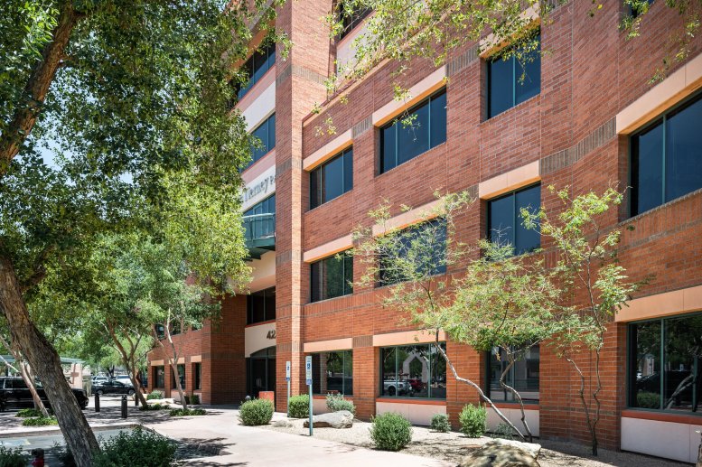 Exterior view of the red brick building at 4250 Drinkwater Blvd, 300, surrounded by green trees.