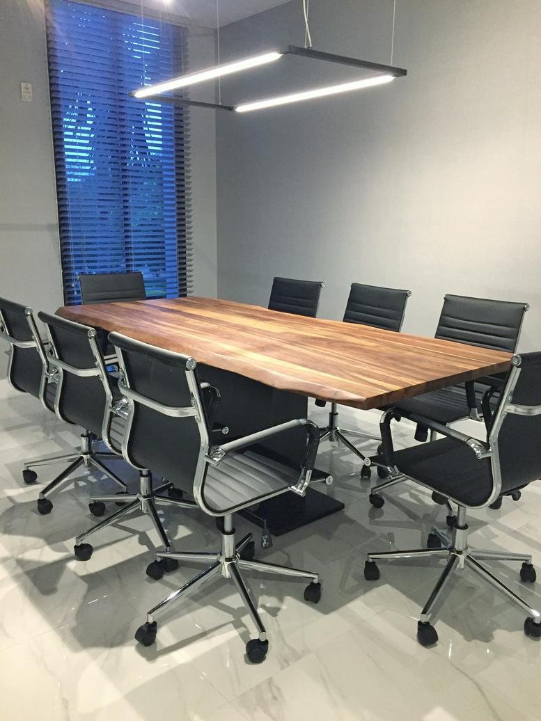 Meeting room at 4300 Biscayne Boulevard Suite 203 with a large wood table and modern black chairs.