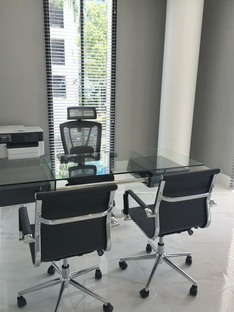 Private office at 4300 Biscayne Boulevard Suite 203 with a glass desk and ergonomic chairs.