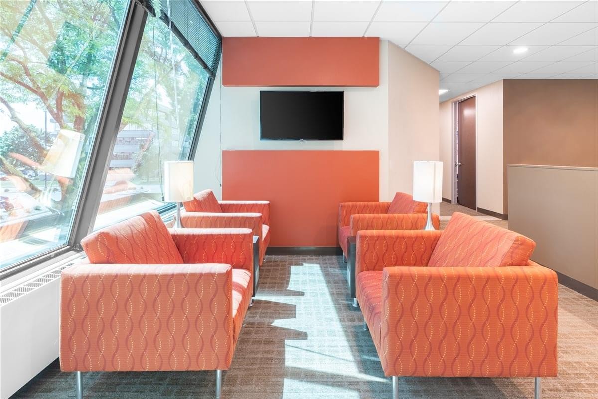Comfortable lounge area at 4321 West College Avenue, Suite 200, Fox River Mall with orange armchairs and a TV.