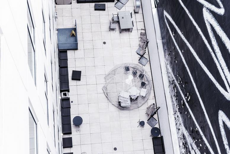 Rooftop deck showing seating areas and artistic mural on a side wall.