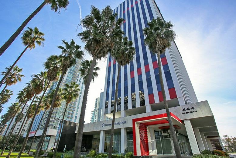Exterior view of the skyscraper at 444 West Ocean, Long Beach Plaza, framed by palm trees.