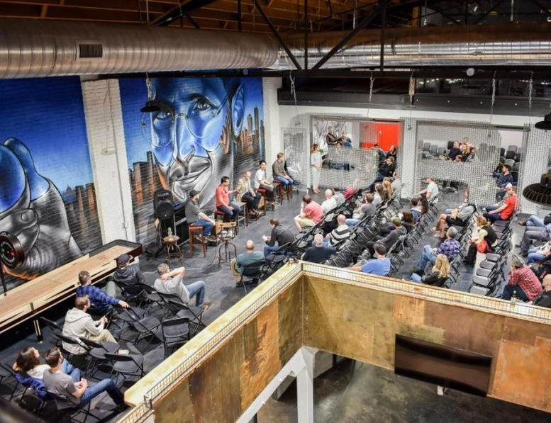 Spacious communal lounge and event space at 445 N Broadway, Denver, Colorado with mural and tiered seating.