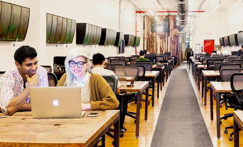 Long open-plan workspace at 447 Broadway, 2nd Floor with rows of wooden desks and industrial ceilings.