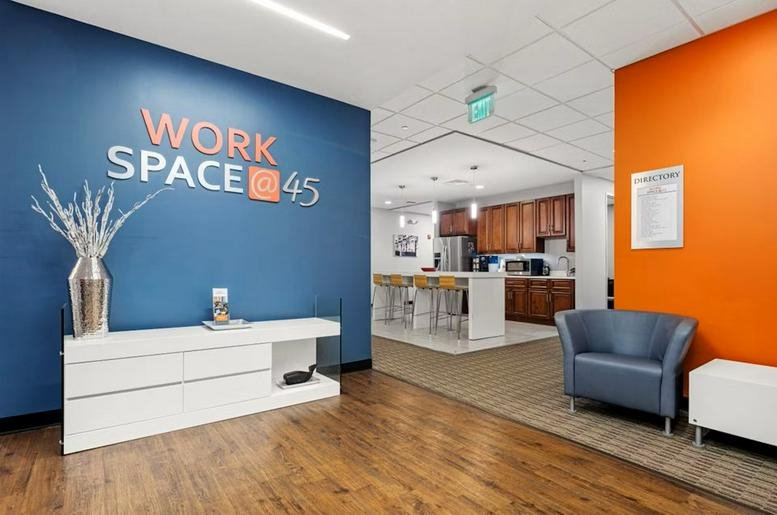 Modern reception area at WorkSpace@45 with a blue feature wall and lounge seating.