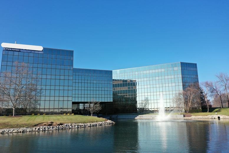 Exterior view of the glass-facade 4555 Lake Forest Drive, Blue Ash Center with a fountain and pond.