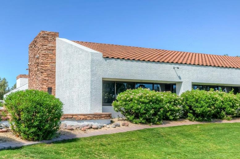 Exterior view of the white stucco building with a red tiled roof at 4700 S Mill Avenue.