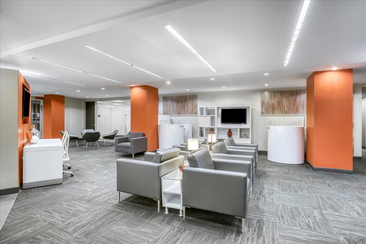 Spacious lounge area with gray seating and bold orange architectural columns.