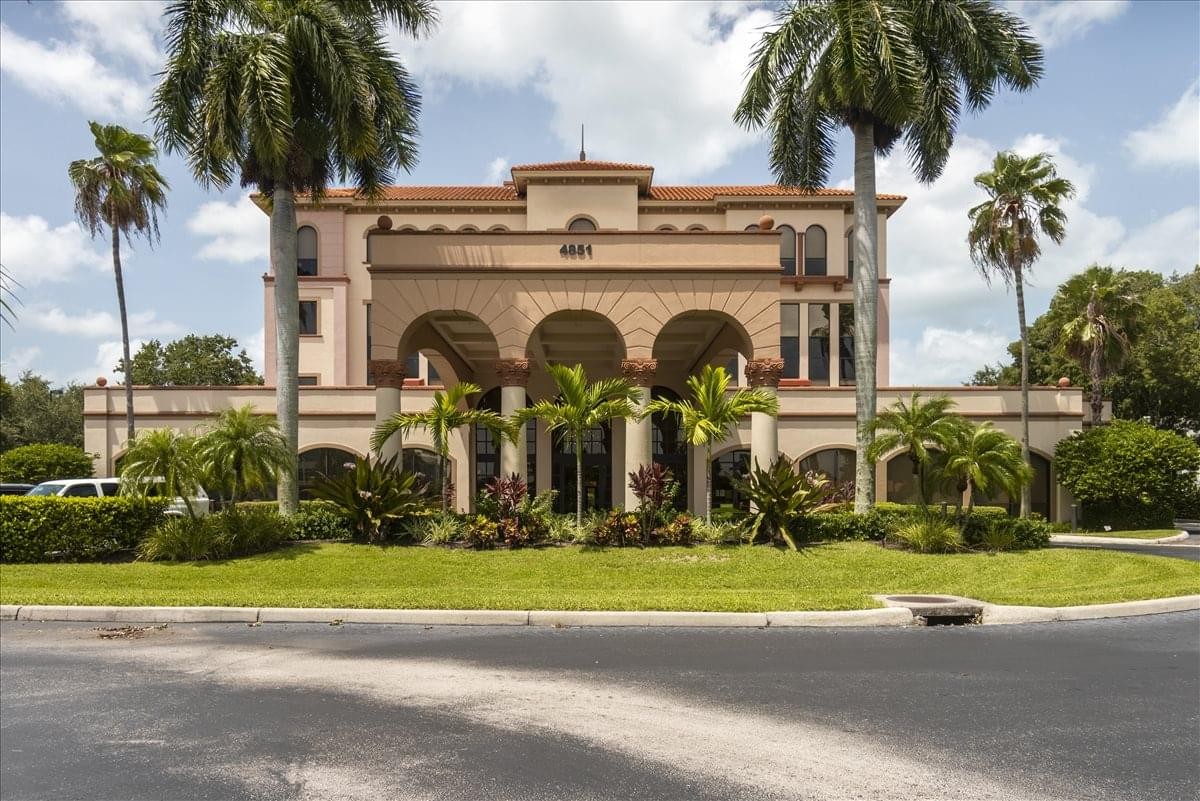 Symmetrical exterior view of the Mediterranean-style 4851 Tamiami Trail North building.