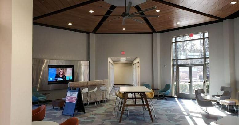 Spacious communal lounge at Business Center International with vaulted wood ceilings and a media wall.