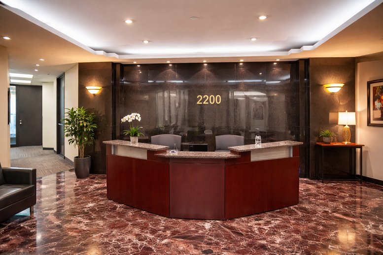 Reception area featuring a dark wood front desk and marble flooring.