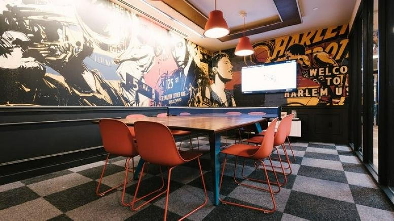 A stylish dining area at 5 W 125th Street, Harlem, New York featuring a ping pong table and vibrant wall murals.