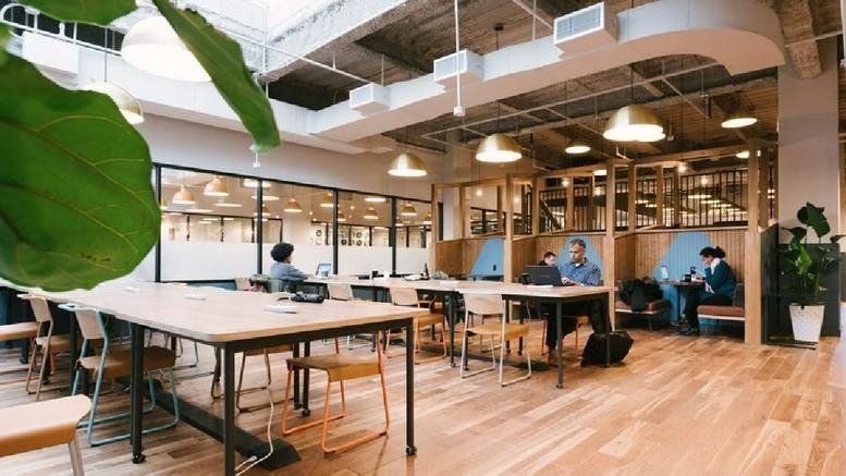 Spacious open-plan lounge at 5 W 125th Street, Harlem, New York with wooden floors and skylights.
