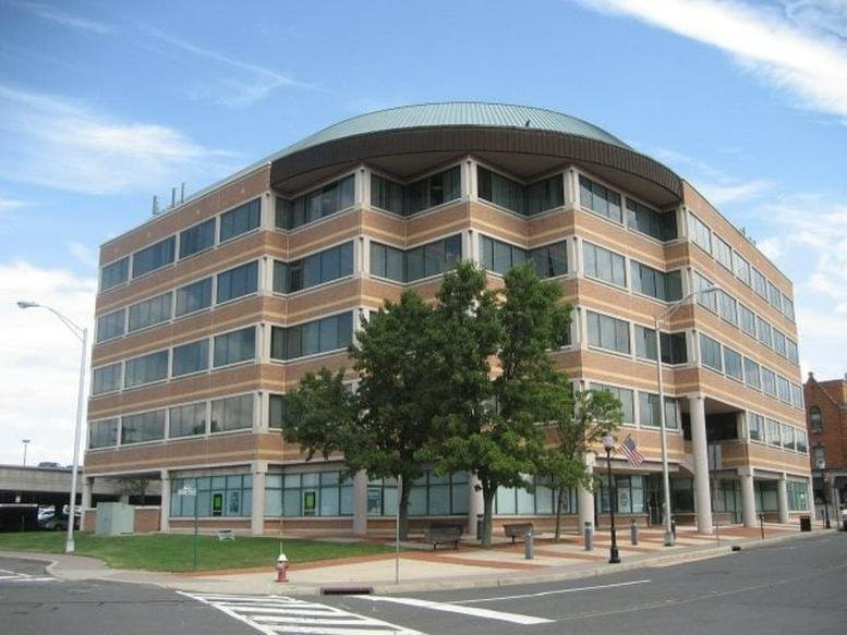 The brick facade and curved roofline of the 50 Division Street office building in Somerville.