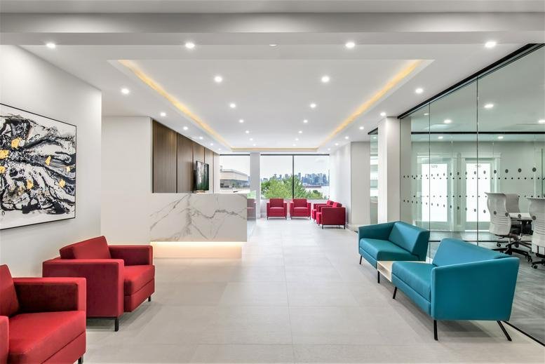 Spacious modern lobby with white marble reception desk and vibrant red and teal seating.