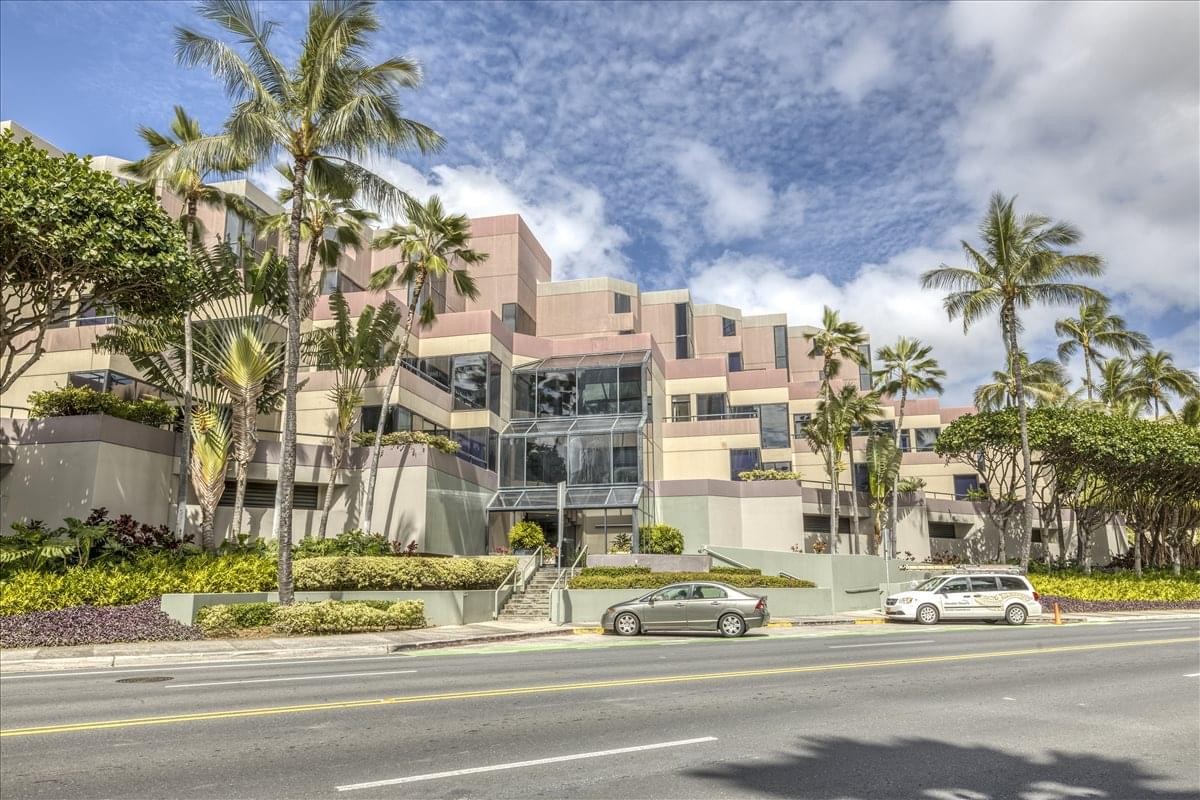 Exterior view of the stepped facade at Seven Waterfront Plaza surrounded by tropical palm trees.