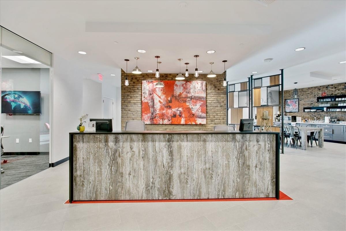 Professional reception desk with a wood-texture facade and vibrant abstract painting behind it.