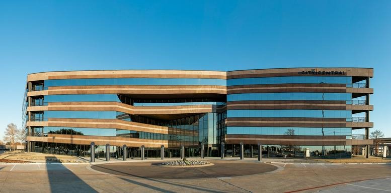 Exterior view of the modern glass and wood-paneled building at 500 North Central Expressway.