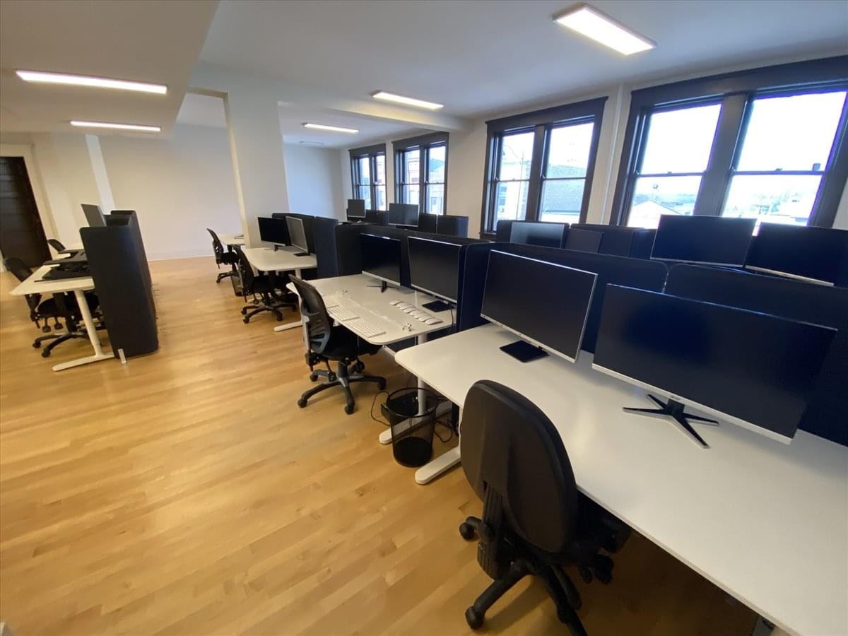 Spacious open-plan workspace at 500 Place d’Armes with rows of desks and large windows.