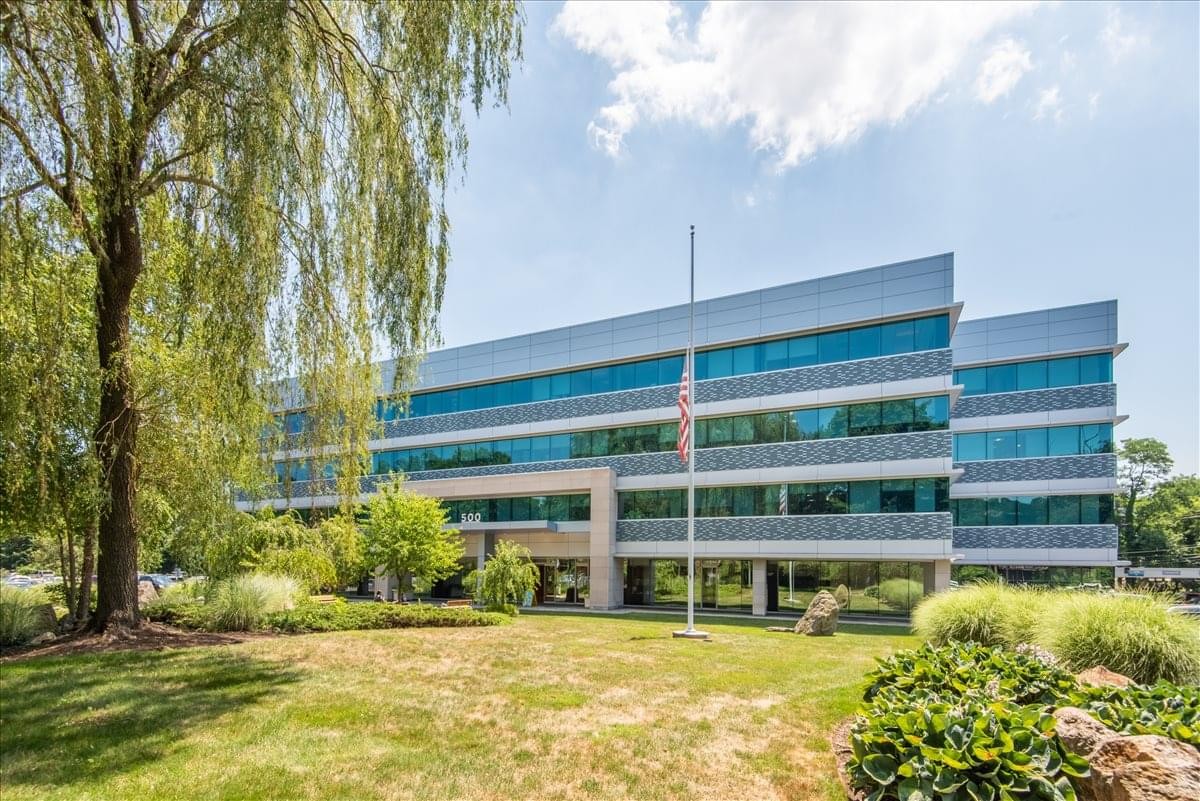 Exterior view of the four-story professional building at 500 W Putnam with large glass windows and green lawns.