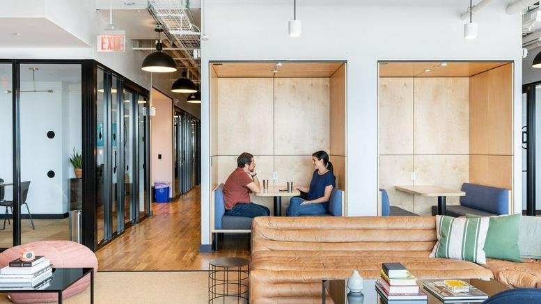 Spacious, modern lounge at 501 Boylston, Boston, Massachusetts featuring wooden booths and leather sofas.