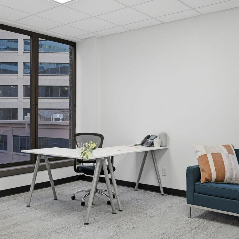 Private office at 501 Union Street, Suite 400 featuring an L-shaped desk and large windows.