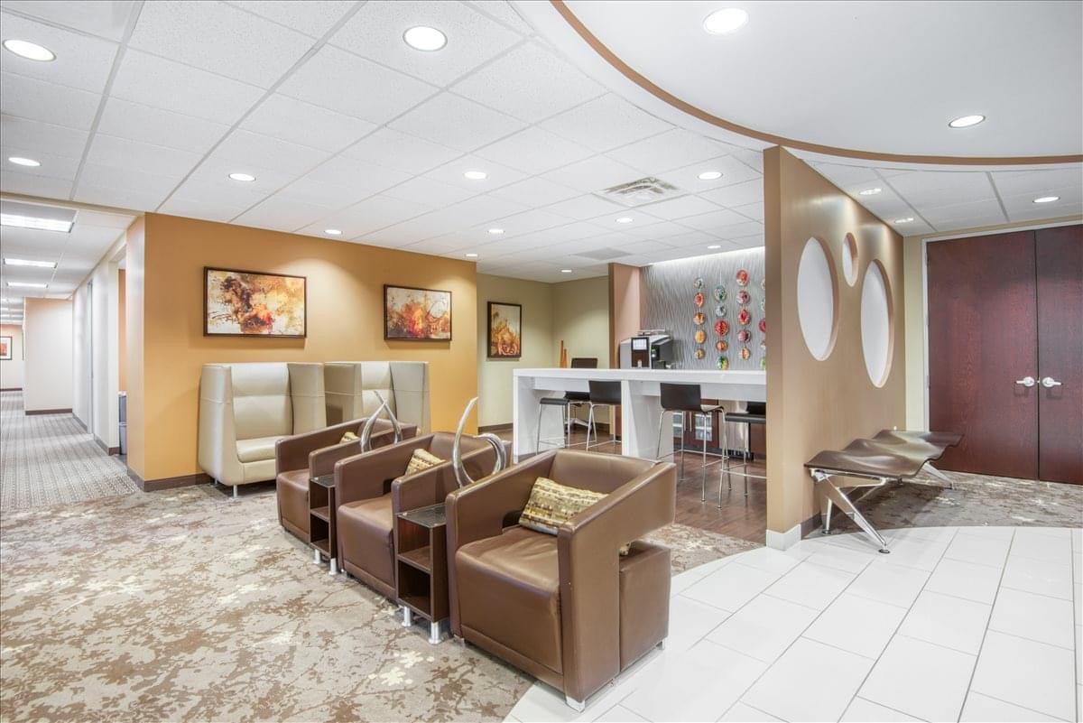 Inviting communal lounge and breakout area with comfortable brown armchairs at 510 Clinton Square.