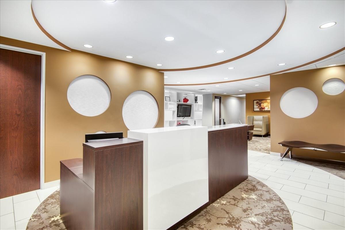 Modern reception area at 510 Clinton Square with a sleek wood and white front desk.