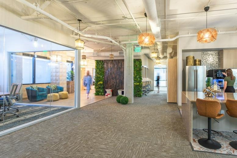 Vibrant communal kitchen and breakout space with a living wall and modern breakfast bar seating.