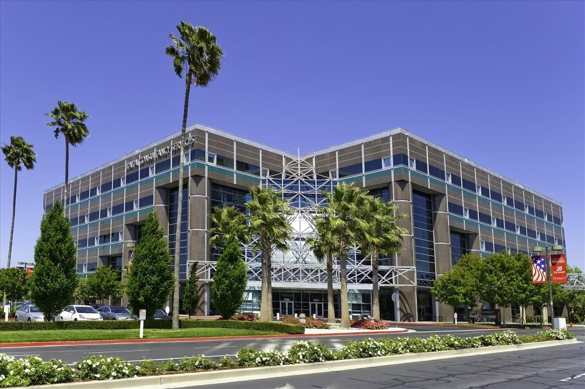Exterior view of the multi-story Techmart Center building with palm trees and a blue sky.