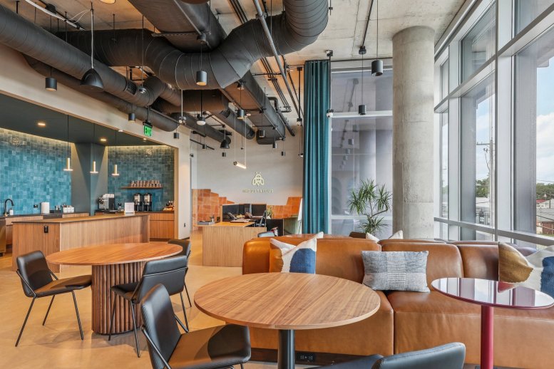Industrious Victory Plaza reception area with mid-century modern furniture and industrial ceiling.